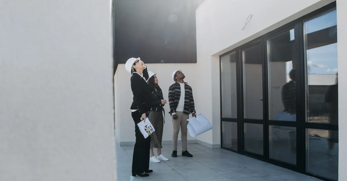 Grupo de agentes inmobiliarios evaluando un edificio moderno durante el día.