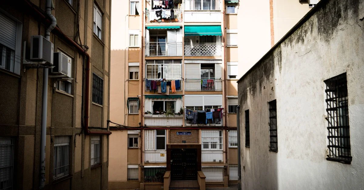 Vista exterior de un edificio de apartamentos en la ciudad con ropa tendida, capturando la esencia de la vida urbana.