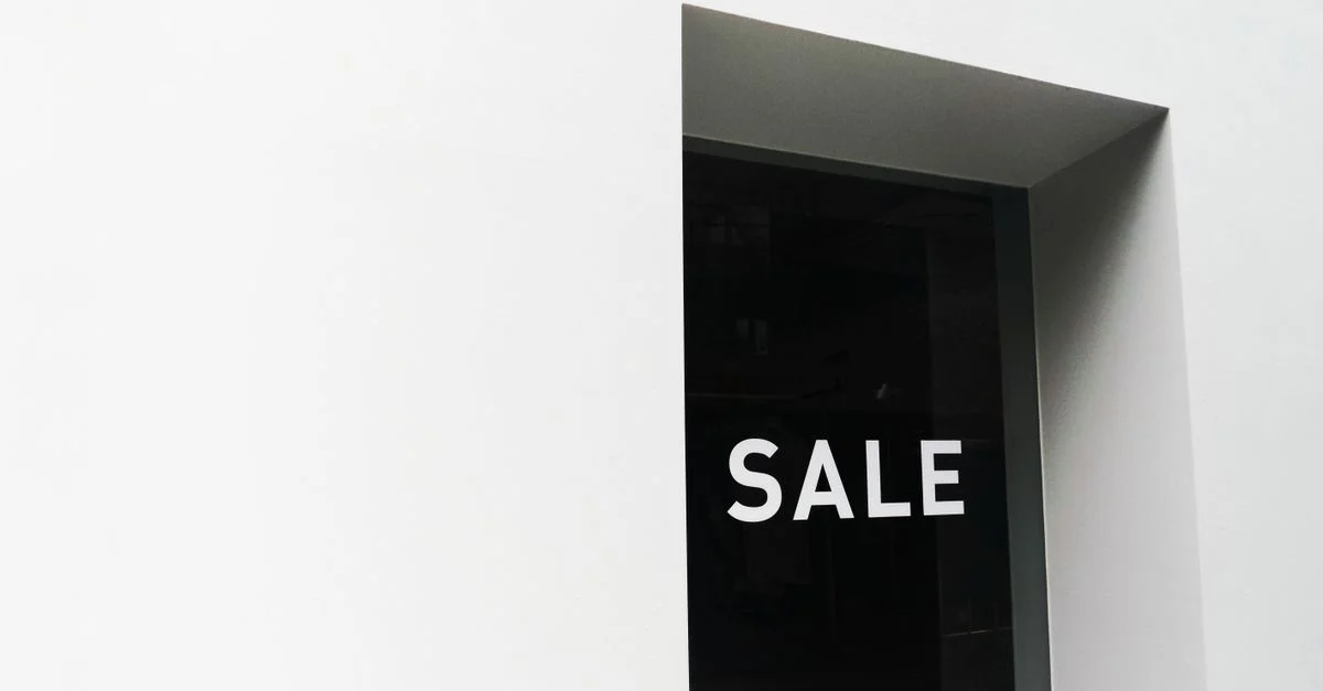 Una imagen minimalista en blanco y negro de un cartel de venta en una vitrina con amplio espacio negativo.