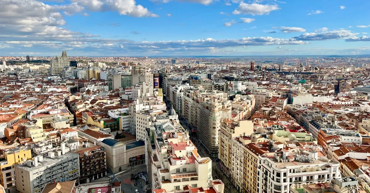 Impresionante vista aérea del horizonte de Madrid con un paisaje urbano vibrante bajo un cielo azul.